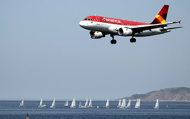 In the forefround an Avianca airliner lands in the Santos Dumont airport (not framed) as sailing boats compete in the International Sailing Regatta held in the Guanabara Bay in Rio de Janeiro, Brazil on August 19, 2015, an event that serves as a test for the Rio 2016 Olympic Games. AFP PHOTO/VANDERLEI ALMEIDA ORG XMIT: VAN971LEGENDA DO JORNALAvião da Avianca pousa no aeroporto de Santos Dumont