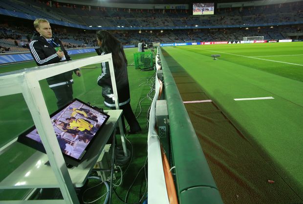 FIFA officials stand near a monitor used by the video assistant referee (VARs) set up on the sideline of the pitch at Yokohama International Stadium prior to the semifinal match between Real Madrid and Club America at the FIFA Club World Cup soccer tournament in Yokohama, near Tokyo, Thursday, Dec. 15, 2016. (AP Photo/Shizuo Kambayashi) ORG XMIT: TTX101