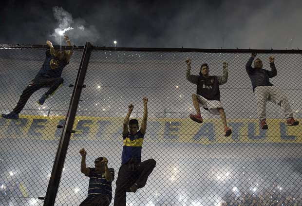 TOPSHOTS Argentina's Boca Juniors supporters cheer for their team during their Copa Libertadores 2015 round before the quarterfinals second leg football match between Argentina's Boca Juniors and Argentina's River Plate at the "Bombonera" stadium in Buenos Aires, Argentina, on May 14, 2015. AFP PHOTO / JUAN MABROMATA ORG XMIT: MAB462