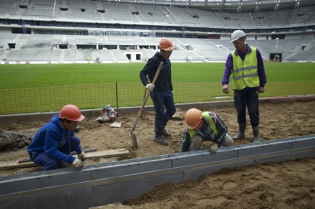 FILE In this file photo taken on Wednesday, Sept. 7, 2016Workers at the Luzhniki stadium, which is undergoing a major rebuild to be ready to host the 2018 World Cup final, in Moscow, Russia. A new report by Human Rights Watch says workers building stadiums for next year's soccer World Cup in Russia have faced repeated abuses and at least 17 have died. The report says workers on several stadiums have routinely gone unpaid for several months. (AP Photo/Ivan Sekretarev, file) ORG XMIT: XAZ129