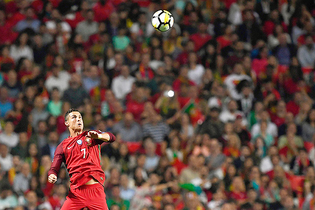 Portugal's midfielder Cristiano Ronaldo jumps for the ball during the FIFA World Cup 2018 Group B qualifier football match between Portugal and Switzerland at the Luz Stadium in Lisbon on October 10, 2017. / AFP PHOTO / FRANCISCO LEONG ORG XMIT: 3210