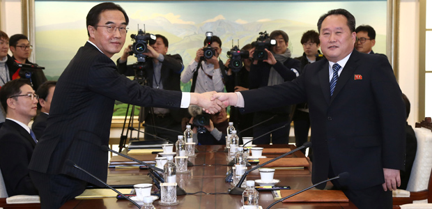 Membros das delegações da Coreia do Sul (dir.) e da Coreia do Norte se encontram