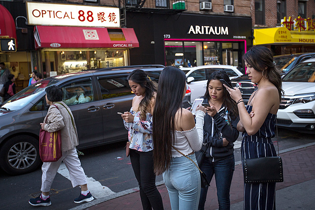 FILE -- People on their phones in Manhattan's Chinatown neighborhood, Sept. 9, 2017. Facebook announced sweeping changes to its News Feed on Jan. 11, 2018, saying that it would prioritize what their friends and family share and comment on while de-emphasizing content from publishers and brands. (Ali Asaei/The New York Times)