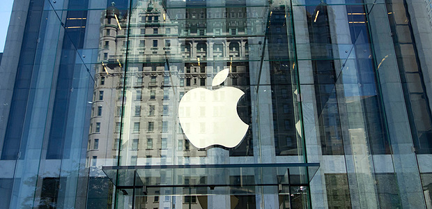 (FILES) This file photo taken on September 14, 2016 shows the Apple logo at the entrance to the Fifth Avenue Apple store in New York. Apple announced January 17, 2018 it would pay some $38 billion in taxes -- likely the largest payment of its kind -- on profits repatriated from overseas as it boosts investments in the United States.The iPhone maker said in a statement it plans to use some of its foreign cash stockpile of more than $250 billion, which qualifies for reduced tax rates under a recent bill, to invest in new projects, with estimated investments of $75 billion in the US. / AFP PHOTO / Don EMMERT