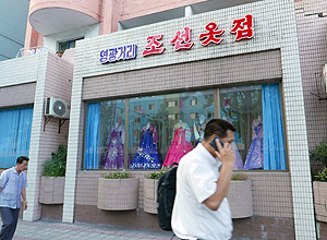 Homem fala ao celular em Pyongyang