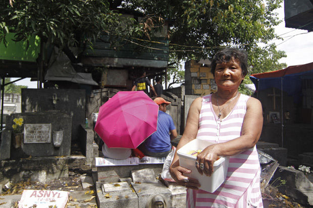 Aurora Cura, 63, moradora do cemitrio municipal de Pasay, na regio metropolitana de Manila, segura caixa com maos de cigarro, que vende por unidade aos frequentadores do local; cerca de 50 famlias moram dentro desse cemitrio e ganham dinheiro limpando e pintando os tmulos e vendendo comida, bebida, cigarro e outros objetos