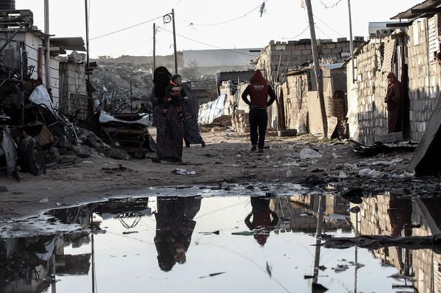 Palestinos andam em rua de uma das favelas da cidade de Khan Yunis, no sul da faixa de Gaza