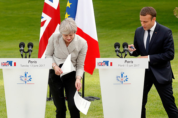 French President Emmanuel Macron (R) watches as Britain's Prime Minister Theresa May recovers a sheet of notes which fell at the start of a joint statement at the Elysee Palace in Paris, France, June 13, 2017. REUTERS/Philippe Wojazer ORG XMIT: PHW122