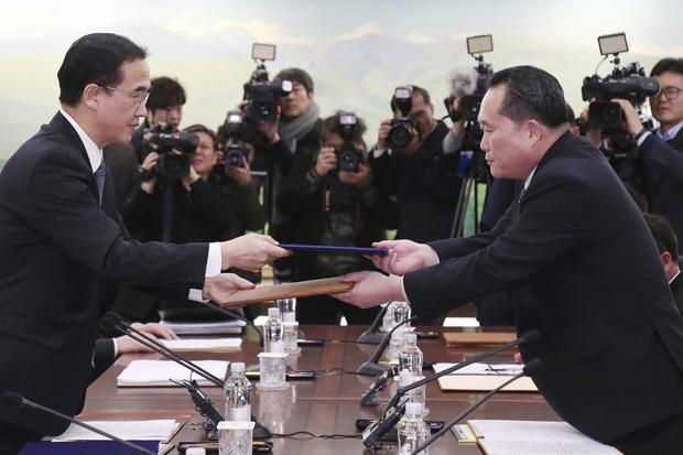 The head of North Korean delegation Ri Son Gwon, right, exchanges documents with South Korean Unification Minister Cho Myoung-gyon after their meeting at Panmunjom in the Demilitarized Zone in Paju, South Korea, Tuesday, Jan. 9, 2018. The rival Koreas took steps toward reducing their bitter animosity during rare talks Tuesday, as North Korea agreed to send a delegation to next month's Winter Olympics in South Korea and reopen a military hotline. (Korea Pool/Yonhap via AP) ORG XMIT: XAHN816
