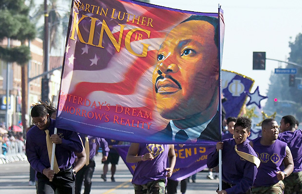 Participants march in the 33rd annual Kingdom Day Parade honoring Dr. Martin Luther King Jr., January 15, 2018 in Los Angeles, California. The theme of this year's parade is ``When They Go Low, We Go High,'' inspired by a speech by former First Lady Michelle Obama at the 2016 Democratic National Convention. / AFP PHOTO / Robyn Beck