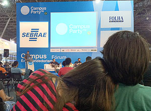 Casal assiste a palestra no palco de empreendedorismo (Alexandre Aragão/Folhapress)