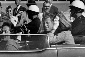 O ento presidente John Kennedy desfila em carro aberto, ao lado de sua mulher, Jacqueline Kennedy, pouco antes de ser assassinado