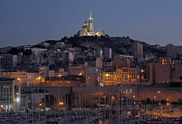 Vista noturna do porto de Marselha com a basílica de Notre Dame de la Garde ao fundo, na região de Provença 