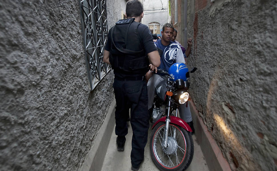 Policial civil revista moradores na favela do Jacarezinho, na zona norte do Rio <b>