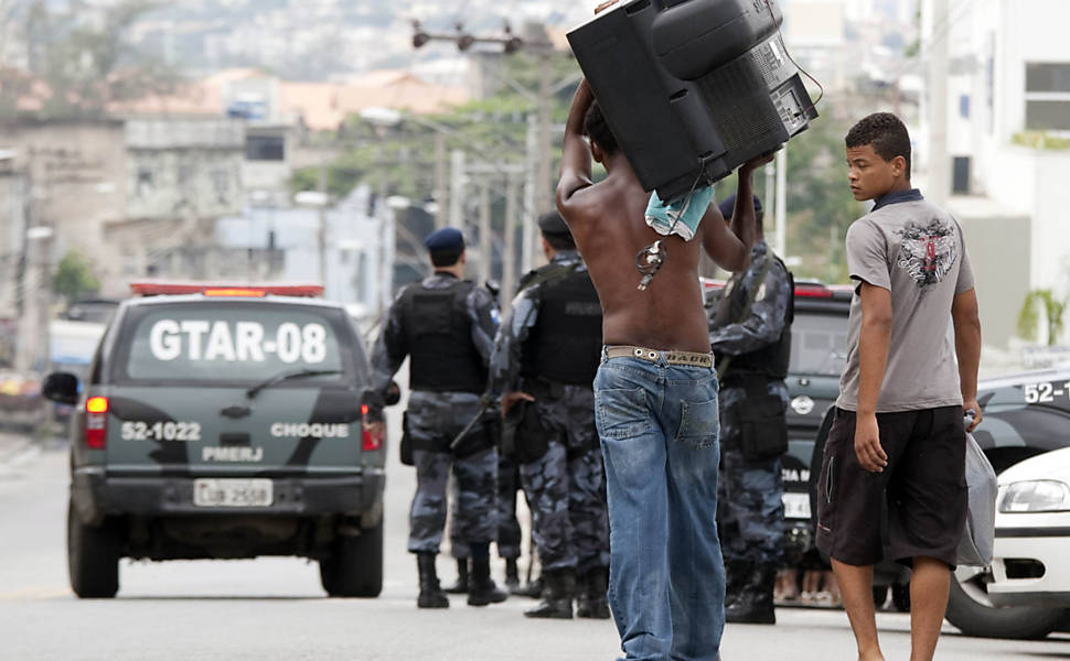 Morador do Complexo do Alemão, na zona norte do Rio, deixa o local um dia antes de tropas ocuparem o conjunto de favelas <b>