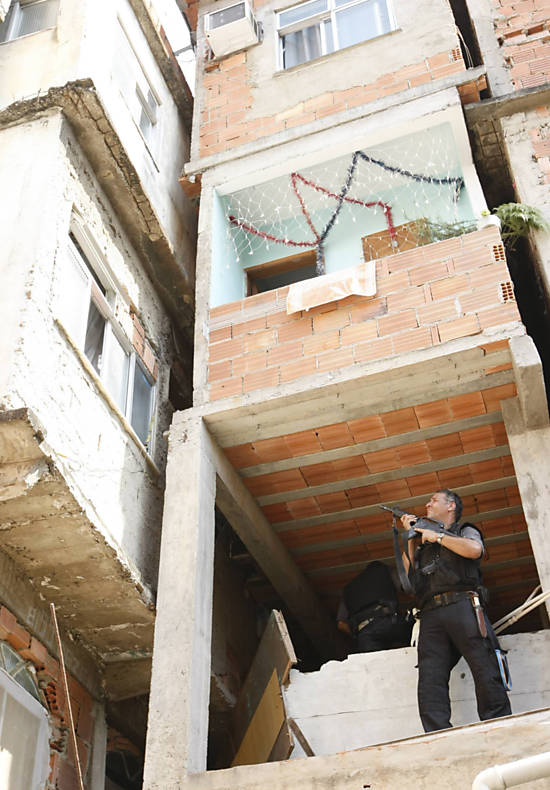 Policial faz varredura um dia após ocupação do Complexo do Alemão, conjunto de favelas na zona norte do Rio <b>
