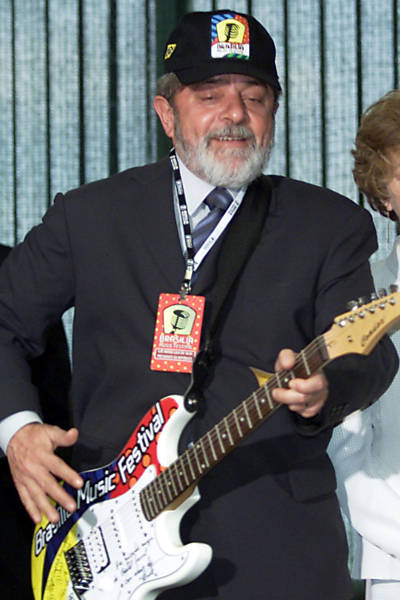 O presidente Luiz Inácio Lula da Silva finge tocar, em Brasília (DF); a guitarra será leiloada, e o dinheiro obtido com a venda será doado para o programa Fome Zero. Lula ganhou a guitarra autografada e um boné do festival Brasília Music Festival durante encontro com os integrantes da banda Capital Inicial