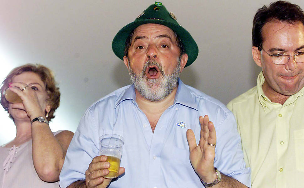 O presidente Luiz Inácio Lula da Silva durante a abertura do 20ª Oktoberfest, tradicional festa da cerveja em Blumenau (SC), usando chapéu típico. Ao beber seu copo de chopp Lula diz para o fotógrafo da Folha "morra de inveja"; depois de beber mandou oferecer a cerveja para o fotógrafo Alan Marques. Ao lado do presidente, a primeira-dama, Marisa Letícia, e o prefeito de Blumenau, Décio Neri de Lima