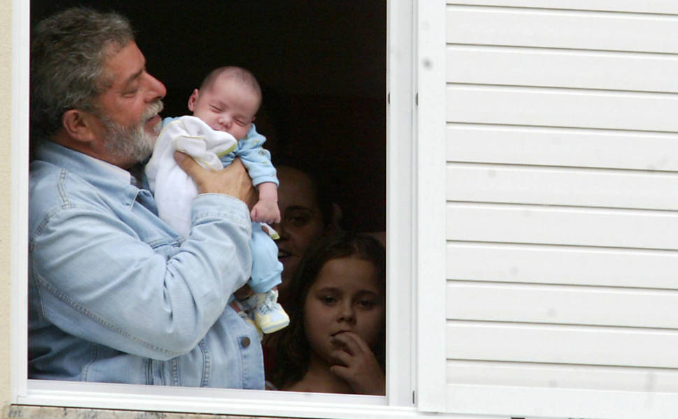 O presidente, Luiz Inácio Lula da Silva, segura seu neto, João Gabriel, na janela do prédio onde mora a sua filha Lurian, na cidade de Florianópolis, Santa Catarina