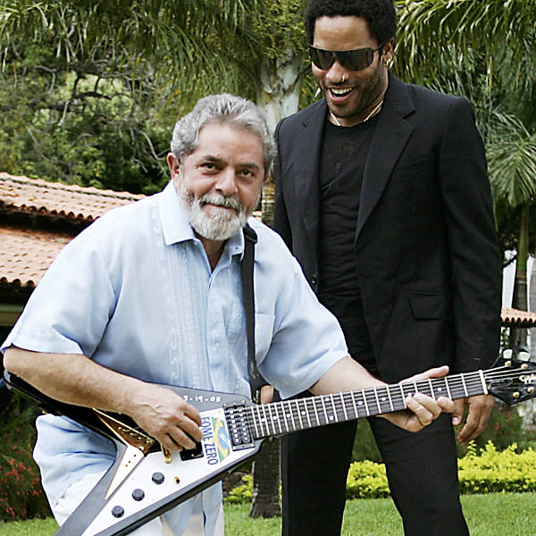 Texto: Política - Música: o presidente Luiz Inácio Lula da Silva, brinca com guitarra doada pelo músico norte-americano Lenny Kravitz ao programa Fome Zero durante visita à residência oficial do presidente, em Brasília (DF). *** In this photo released by the Presidency of Brazil, Brazilian President Luiz Inacio Lula da Silva, left, receives a guitar from American singer Lenny Kravitz, during a visit in the official residency, in Brasilia, Brazil, Saturday, March 19, 2005. Kravitz donated the guitar used in his first Latin American tour to Brazil?s Zero Hunger campaign. The food distribution program seeks to eradicate hunger among the estimated 54 million Brazilians who live on a dollar a day or less. (AP Photo/Ricardo Stuckert-PR). ***EFE OUT***