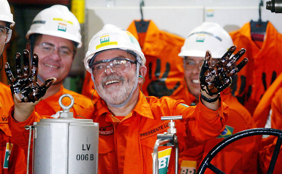 O presidente Luiz Inácio Lula da Silva mostra as mãos sujas de petróleo cru depois de acionar uma das válvulas de controle dos poços do navio-plataforma P 50 da Petrobras, que deu inicio à produção do campo de Albacora Leste na Bacia de Camppos, litoral do estado do Rio de Janeiro. Os milhares de barris de petróleo que começarão a ser extraídos do campo marcarão a auto - suficiência do Brasil na produção de petróleo