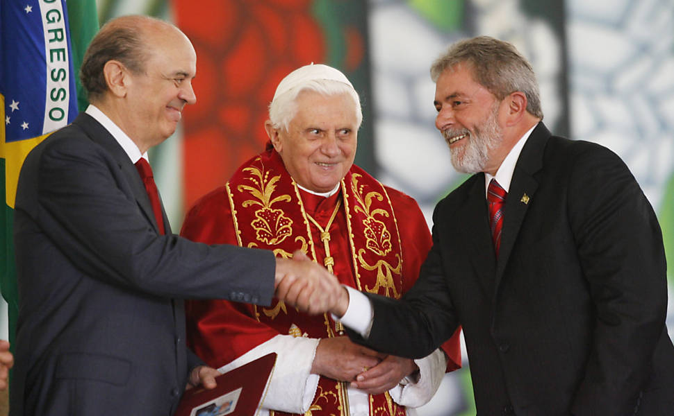 Texto: Visita do Papa Bento 16 ao Brasil: o Papa Bento 16 (centro) observa o cumprimento entre o governador de São Paulo José Serra e o presidente da República Luiz Inácio Lula da Silva, no Palácio dos Bandeirantes, em São Paulo (SP). Brazilian President Luiz Inacio Lula da Silva shakes hands with Sao Paulo State Governor Jose Serra (L), who he beat in the 2006 presidential elections, as Pope Benedict XVI watches during the presentation of a postal stamp commemorating the Pope?s visit to Brazil, at the Bandeirantes Palace in Sao Paulo May 10, 2007. The Pope will be visiting Brazil through Sunday. REUTERS/Jamil Bittar (BRAZIL)