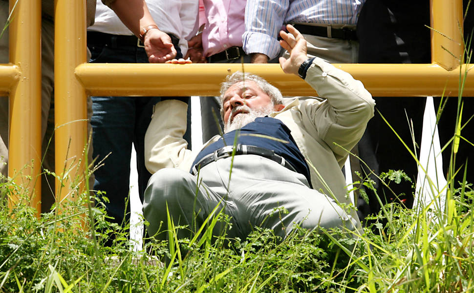 Texto: O presidente Luiz Inácio Lula da Silva passa por baixo de cerca de ferro, desce ladeira e vai até a escada de peixes da represa do rio Manuel Alves durante visita ao projeto de irrigação para o cultivo de frutas e inauguração de barragem perto da cidade de Dianópolis (TO). (Dianópolis (TO), 11.03.2008.13h. Foto de Alan Marques/Folhapress)