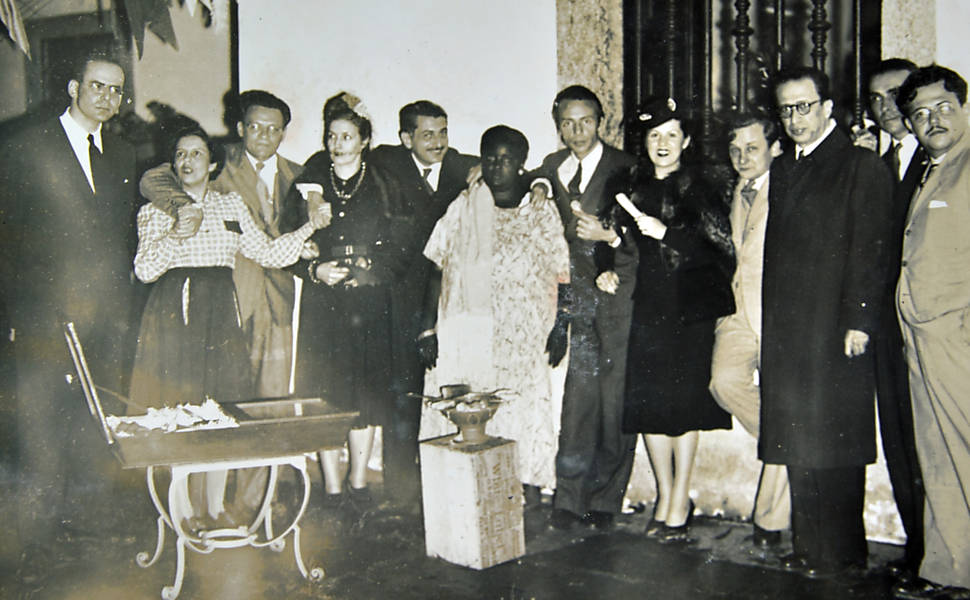 Recepção em casa de Paulo Bitencourt ao Ballet Linconln Kirstein. Gilberto Freyre ao lado de uma baiana.Da esquerda para a direita: 3ªpessoa, José Lins do Rêgo, 5ªPessoa, Gilberto Freyre, 9ªpessoa, Cândido Portinari, 10ª pessoa, Manoel Bandeira, 12ªpessoa, Antiógenes Chaves. Década de 30