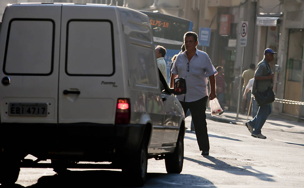 Pedestre atravessa rua do centro de São Paulo em meio a carros, motos e ônibus; centro lidera o ranking de atropelados <b>