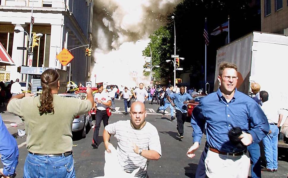 População tenta fugir da onda de poeira formada pelo desabamento das torres gêmeas do World Trade Center <b>