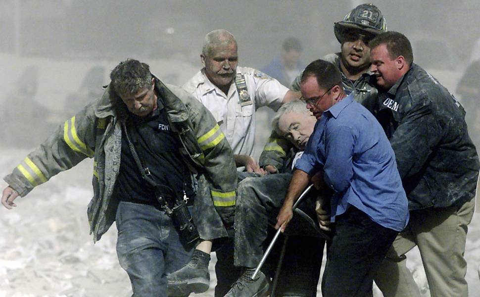 Bombeiro é carregado após desabamento das torres do World Trade Center, em Nova York <b>