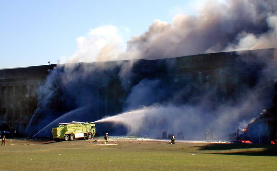 Bombeiros tentam apagar incêndio no prédio do Pentágono minutos após o prédio ser atingido por um avião sequestrado