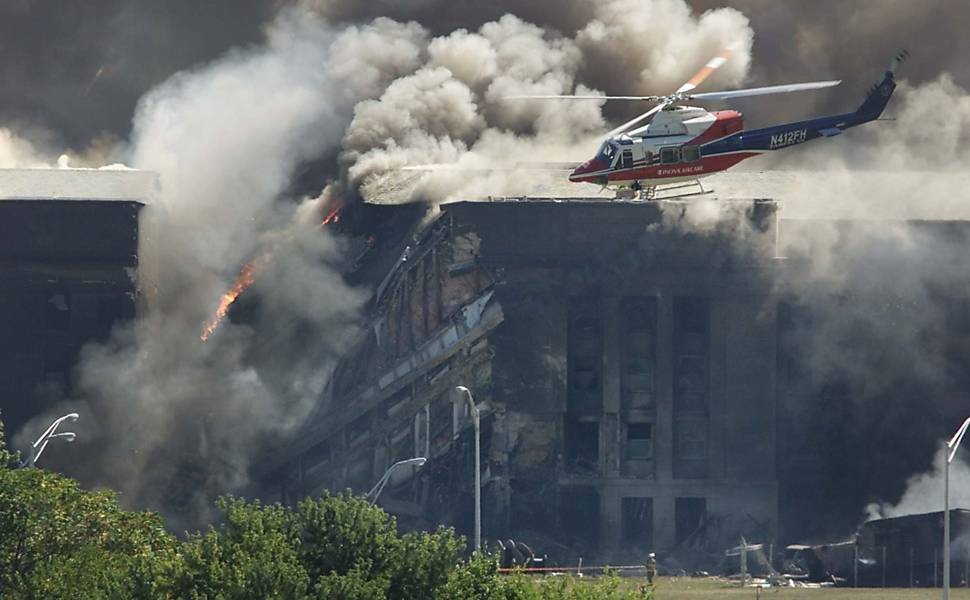 Helicóptero de resgate sobrevoa área danificada do Pentágono enquanto bombeiros tentam controlar as chamas no Pentágono