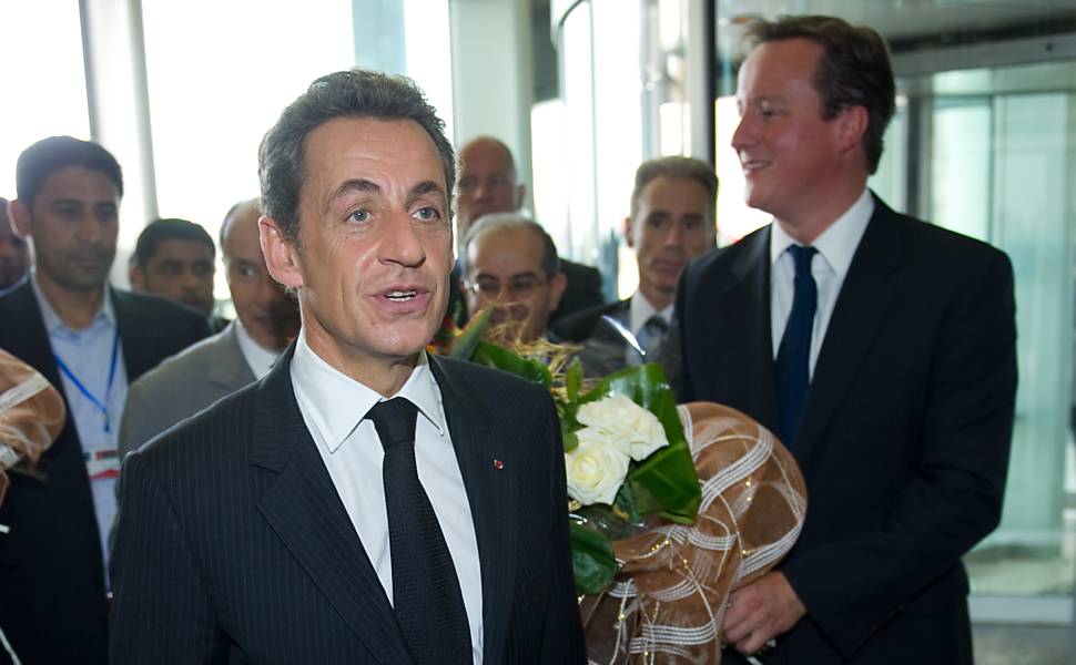 Sarkozy, à esquerda, e Cameron, à direita, chegam no hotel Corinthia, que havia sido palco de confrontos em Trípoli