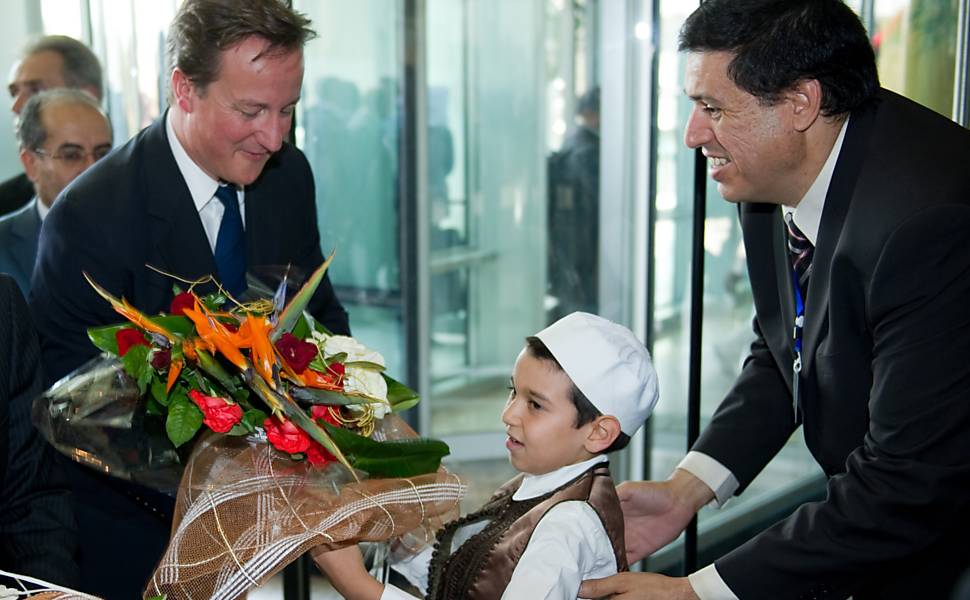 Líderes europeus recebem flores de criança em sua chegada a hotel na capital, Trípoli