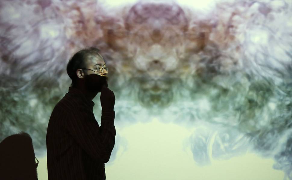 Visitante passeia em sala com filmes relacionados ao cérebro humano