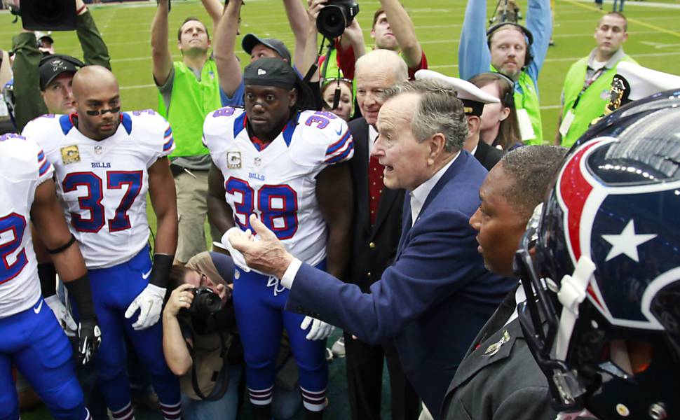 George H. W. Bush e o ex-secretário de Estado americano Jim Baker jogam a moeda antes de partida de futebol americano em Houston, em 2012