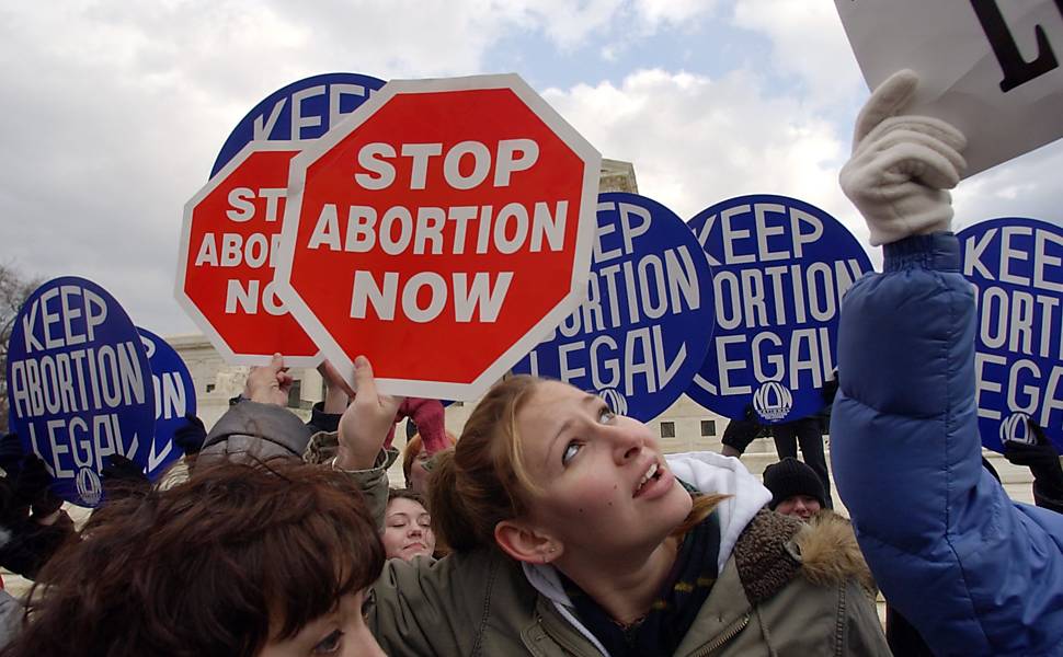 Cartazes pró e anti-aborto são mostrados em frente à Suprema Corte, em Washington, no 31º aniversário da decisão do caso Roe ?versus? Wade