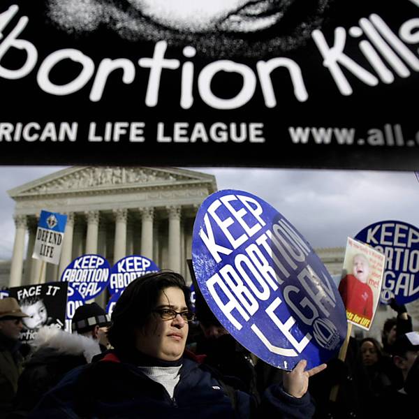 Cartazes pró e anti-aborto são mostrados em frente à Suprema Corte, em Washington