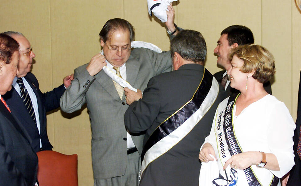 Lula coloca a faixa de campeão brasileiro no ministro chefe da Casa Civil, José Dirceu, com Andrés Sanchez, diretor do Corinthians, ao seu lado