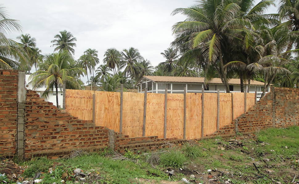 A casa de praia da PC Farias continua conservada, mas o muro lateral foi derrubado e colocaram tapumes para tampar a parte que desabou 