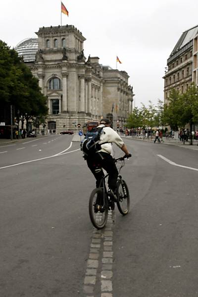 Homem pelada sobre a marca do Muro de Berlim, em direção ao Parlamento