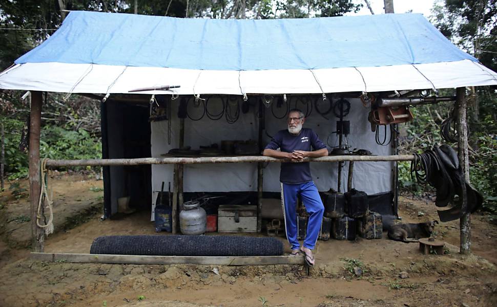Homem no comando de mina de ouro ilegal em frente à sua barraca, dentro da floresta amazônica, perto da cidade de Morais Almeida (PA)