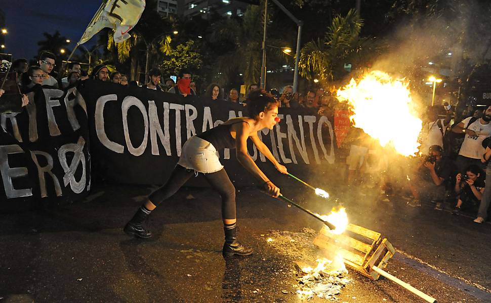 Manifestante cospe fogo em caixa de madeira durante protesto contra o aumento 