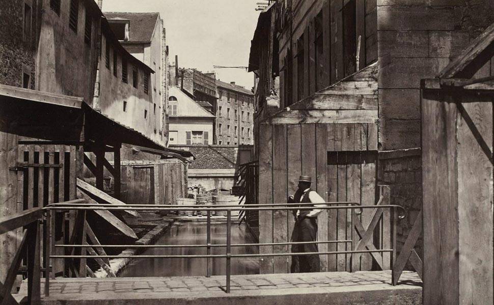 Contratado como fotógrafo oficial da cidade em 1862, Marville acompanhou o desaparecimento da velha Paris e as mudanças físicas e sociais trazidas com a modernização. Esta foto mostra as margens do Rio Bièvre em 1862