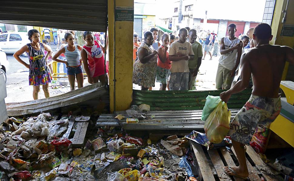 Um homem carrega mercadorias de um supermercado que foi saqueado durante a greve da polícia em Salvador, na Bahia