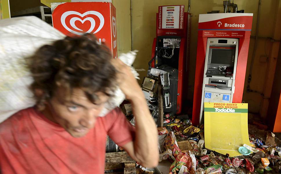 Um homem carrega mercadorias de um supermercado que foi saqueado durante a greve da polícia em Salvador, na Bahia