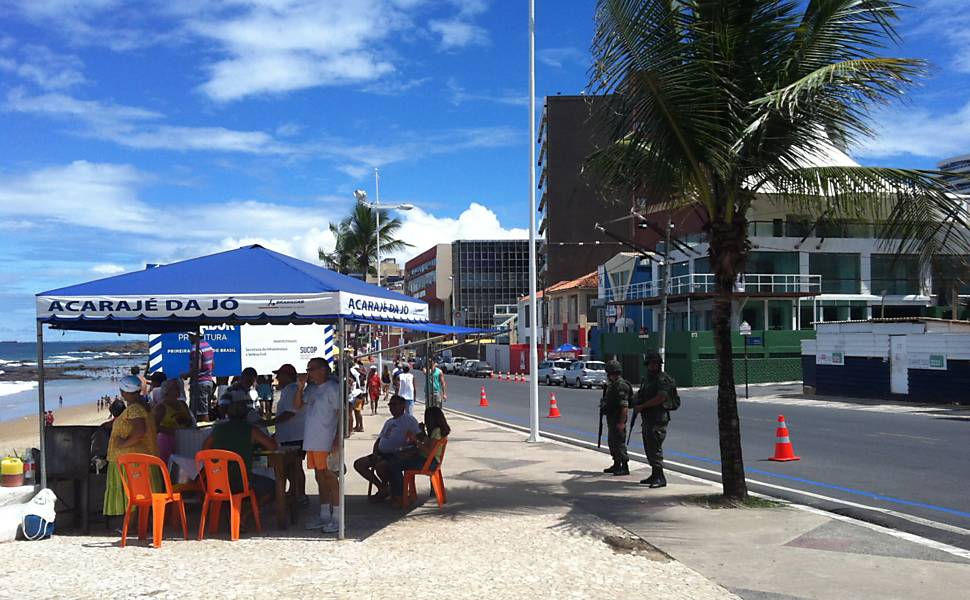 Exército faze policiamento ao lado de barraca de acarajé, na orla da praia, em Salvador
