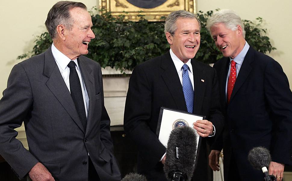 O ex-presidente dos EUA, George W. Bush, brinca com o pai, George Bush, e com Bill Clinton durante reunião na Casa Branca, em 2005