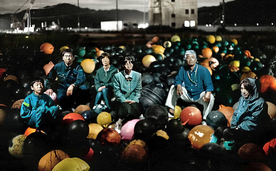 Grupo de pescadores posa para foto em cima de boias usadas na cidade portuária antes de serem arrastadas para terra firme pelas águas